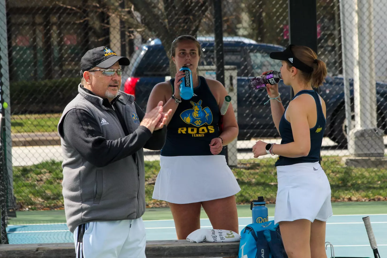 Head Coach Kendell Hale encourages a Roo on the court while Catherine Chrobak and Michela Xibilia stand by.