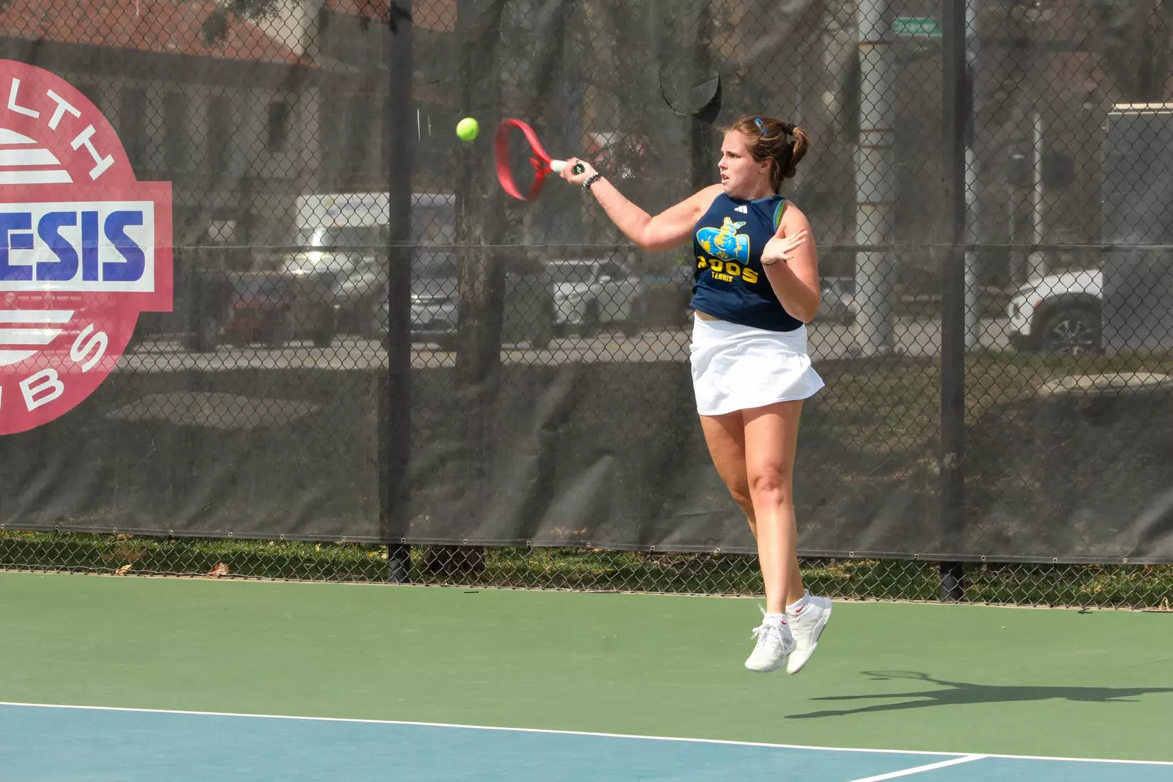 Michela Xibilia goes for a high forehand during her No. 1 singles match against South Dakota. Xibilia dropped her match in two sets.