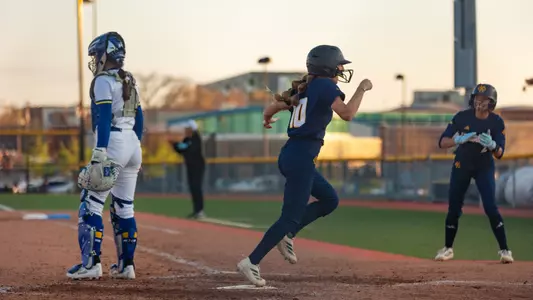 Lauren Parker crosses home plate as Monica Franklin cheers her on in the background during the Roos' 7-5 win over South Dakota State