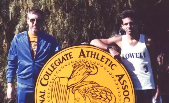 George Davis posing with athlete at NCAA championship.