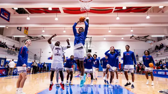 Victor Okojie slam dunk with team around.