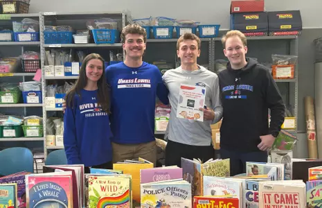 River Hawk athletes pose with books at local school for read across America