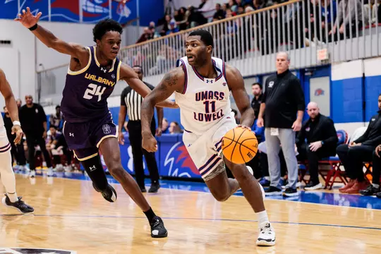 Xavier Spencer dribbling past UAlbany defender
