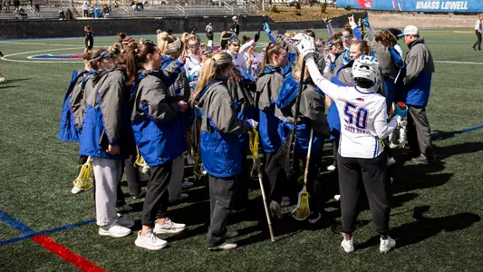 Women's lacrosse team huddled up before game against Bryant