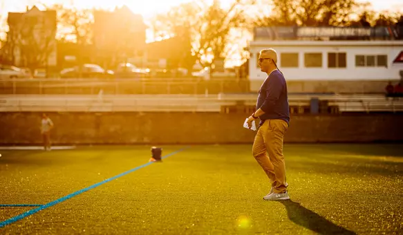 Drew Kelleher walking on field at sunset