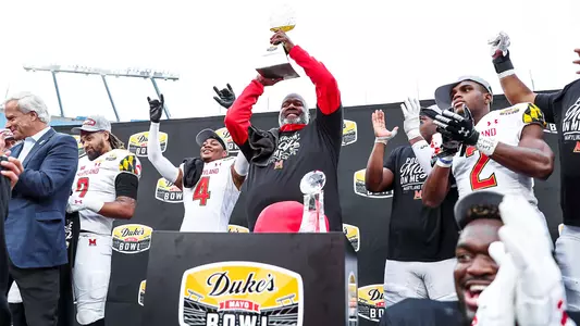 Michael Locksley hoisting Duke's Mayo Bowl trophy