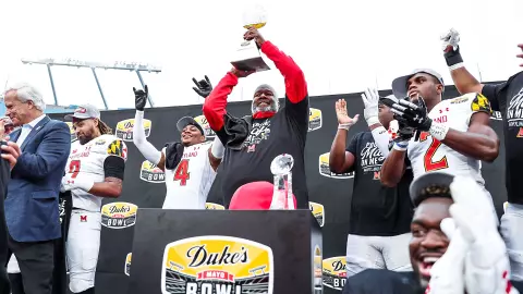 Michael Locksley hoisting Duke's Mayo Bowl trophy