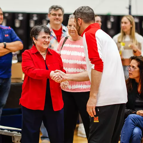 Dr. Pat Danhoff shakes hands with current Maryland gymnastics head coach Brett Nelligan