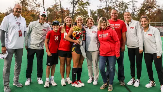 Belle Bressler with coaches, staff and family on Senior Day