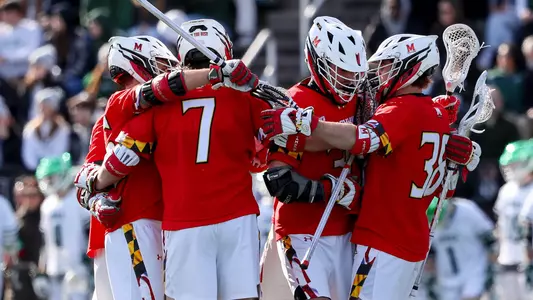 Men's Lacrosse team huddle during Loyola game