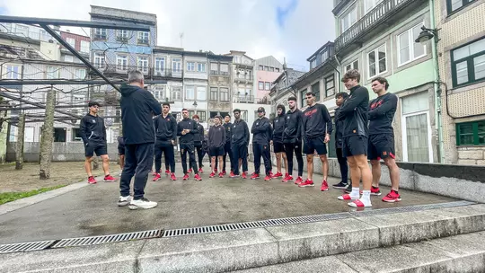 Maryland's Players and Staff stand in a square in Porto, Portugal