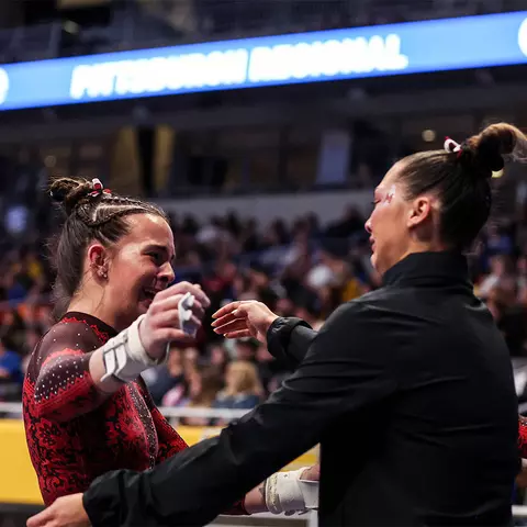 Tasha Brozowski hugs a teammate following her bars routine at the 2023 NCAA Regionals