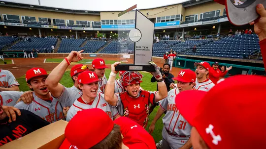 Luke Shliger holds the Big Ten Championship trophy over his head in celebration.