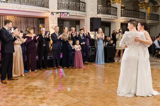 Guests applaud Danielle Malagari Belle and Pride Belle at their wedding