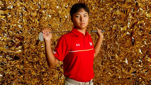 Yang Kuang posed gold backdrop