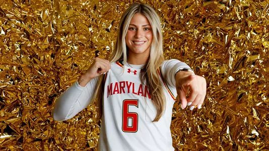 Saylor Poffenbarger white uniform gold backdrop