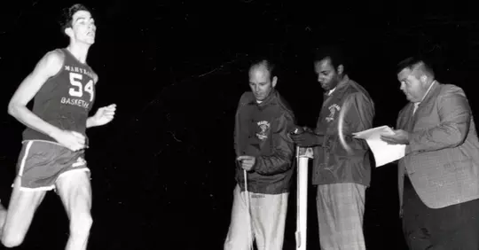 Tom McMillen runs in the first Midnight Mile in 1971 with Lefty Driesell, George Ravling, and Jack Zane looking on.