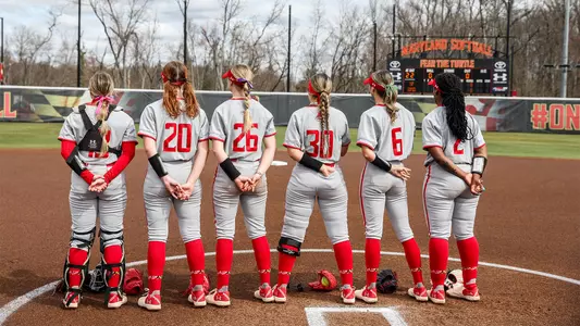 Gracelyn Solarz, Michaela Jones, Sammi Woods, Genevieve Ebaugh, Madison Runyan, and Diamond Williams share a moment pregame during the national anthem
