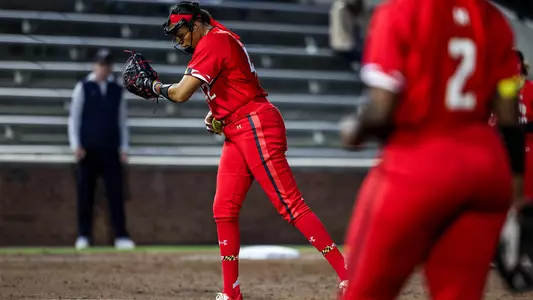 Courtney Wyche looks down at her wristband to receive the pitch call from Coach Karn.