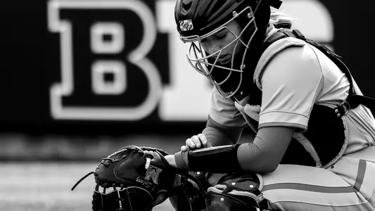 Catcher Gracelyn Solarz looks down at her wristband.