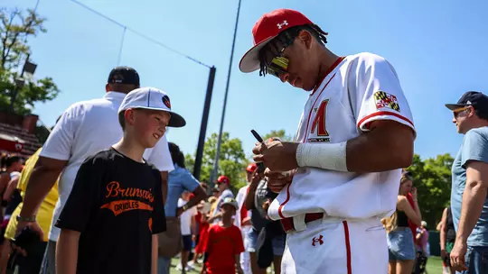 Brayden Martin signing an autograph for a young fan