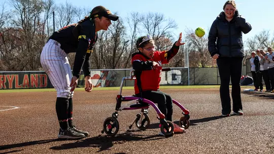 Lily throws out the first pitch at a Maryland softball game in 2024.