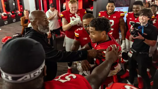 Coach Locksley and the Maryland team embrace Josiah McLaurin in the locker room after the UConn game