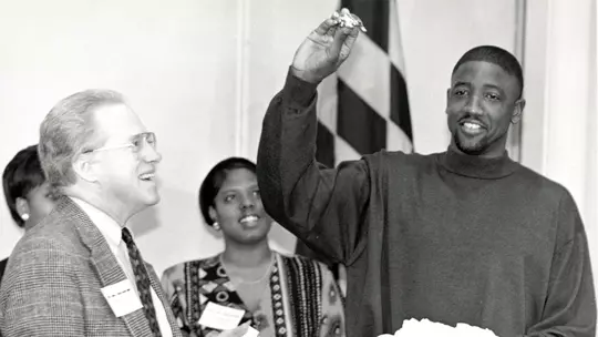 Walt Williams receives a turtle ornament from UMD President Brit Kirwan