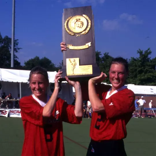 Cathy Reese and Sascha Newmarch holding up the 1998 NCAA Championship trophy