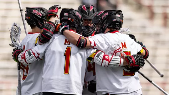 Eric Spanos in the middle of a huddle with his Maryland men's lacrosse teammates