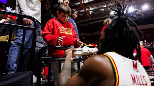 Andre Mills signing an autograph for a fan at XFINITY Center
