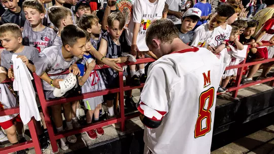 Eric Kolar signing an autograph for a fan after a game at SECU Stadium in 2026
