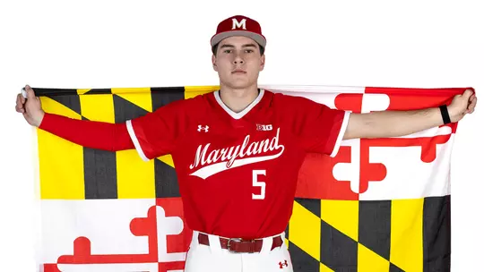 Studio photo of Ty Kaunas with a Maryland state flag across his back on a white backdrop