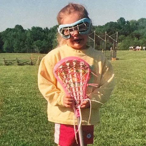 Maddy Sterling holding a lacrosse stick as a young player