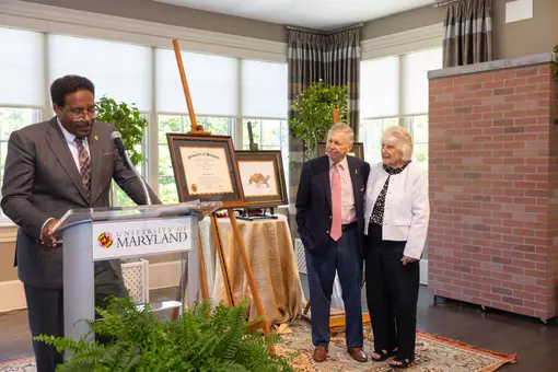 President Darryll Pines presents legendary Voice of the Terps Johnny Holliday with an honorary degree.
