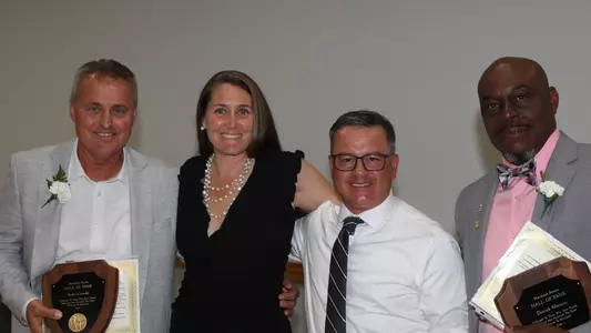 Sasho Cirovski and Ashly Kennedy posing in a photo at the Maryland Soccer Hall of Fame induction ceremony