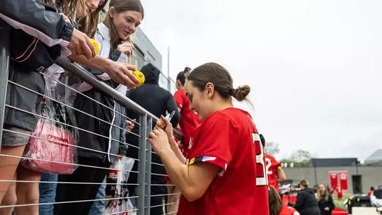 JJ Suriano giving a fan an autograph
