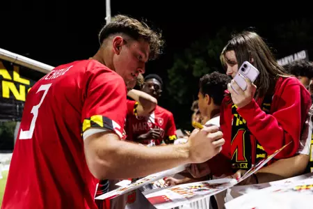 Lilian signs an autograph for fan after UCLA game