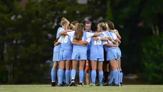 The Tar Heels huddle on Fetzer Field.