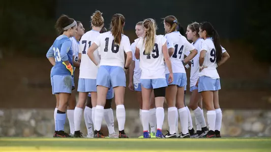 The Tar Heels huddle on Fetzer Field.