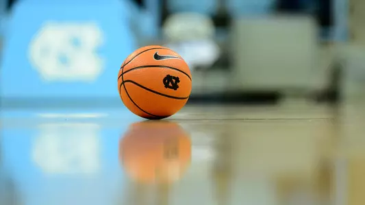 A UNC basketball sits on the Carmichael Arena floor.