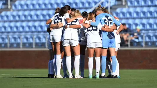 UNC huddles on the field.