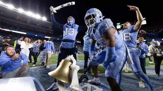 Cedric Gray (33) and Tylee Craft (13) celebrate with the Victory Bell after defeating Duke Saturday night.