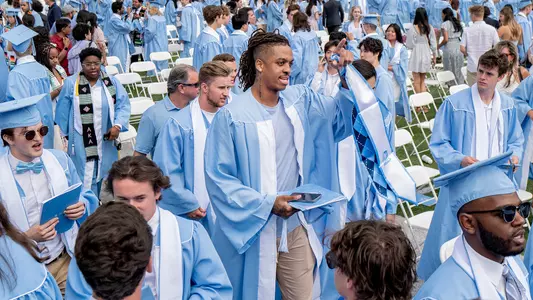 The University of North Carolina celebrated the graduation of nearly 6,500 students at the annual Spring Commencement held May 14, 2023, at Kenan Memorial Stadium. Chancellor Kevin M. Guskiewicz presided over the ceremony with the keynote address being deliverd by Bryan Stevenson, a renowned public interest lawyer and executive director of the Equal Justice Initiative.In this image, men's basketball player Armando Bacot walks with his fellow graduates.(Johnny Andrews/UNC-Chapel Hill)