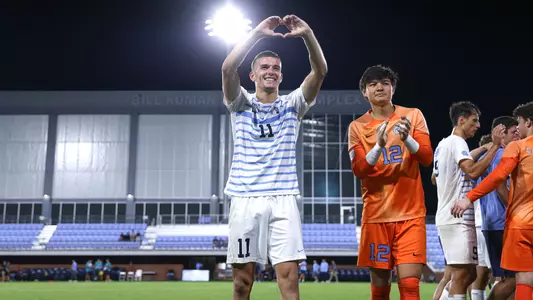 Graduate student Quenzi Huerman (11) makes a heart sign while thanking the crowd for attending UNC’s match against UNC-Wilmington.
