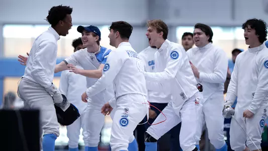 The men’s epee team celebrates a win.