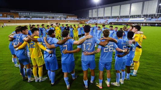UNC huddles on the field after the game.