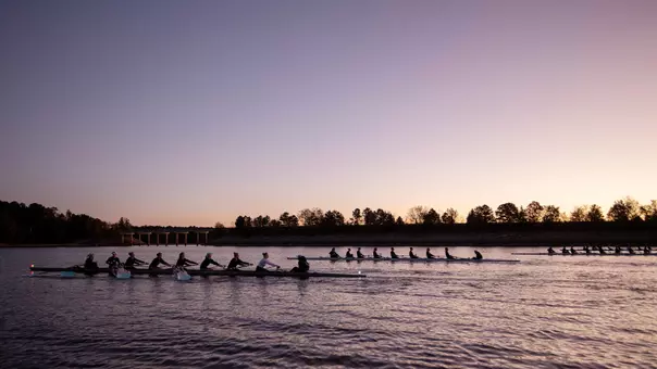 The UNC rowing team takes to the water at sunrise at Jordan Lake for a training session early Thursday morning.