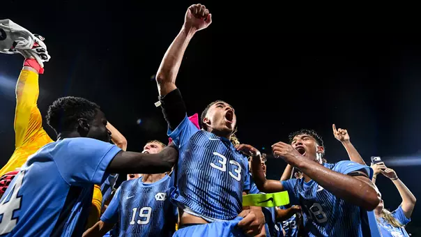 Graduate student Riley Berge (33) celebrates with his teammates after defeating VCU at Dorrance Field Friday night.