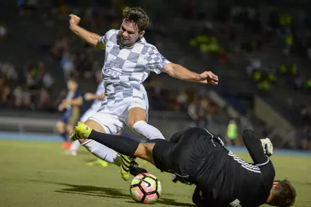 UNF men's soccer player takes on opponent in tackle